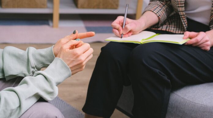 Couples Therapy With a Trainee: What to Ask About Supervision Therapist and client seated in armchairs with a notebook during a consultation