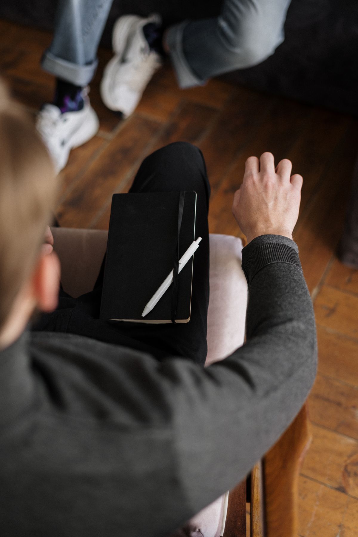 Overhead view of two people in a consultation with a notebook and pen