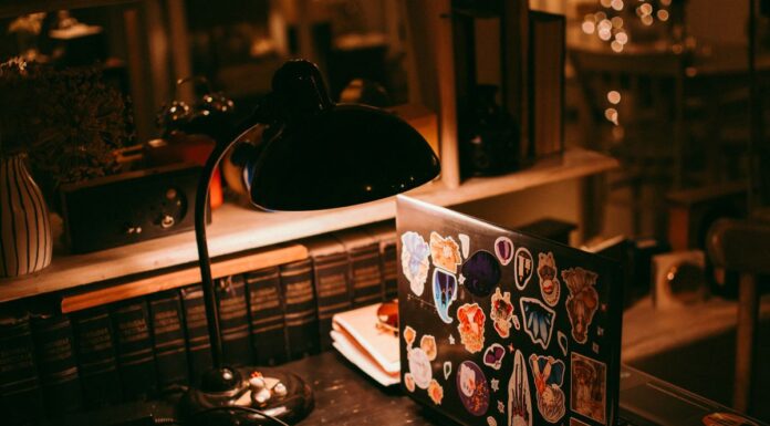 Laptop, lamp, and books on a warmly lit desk
