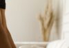 Person folding clean household towels on a sofa as part of the linen routine