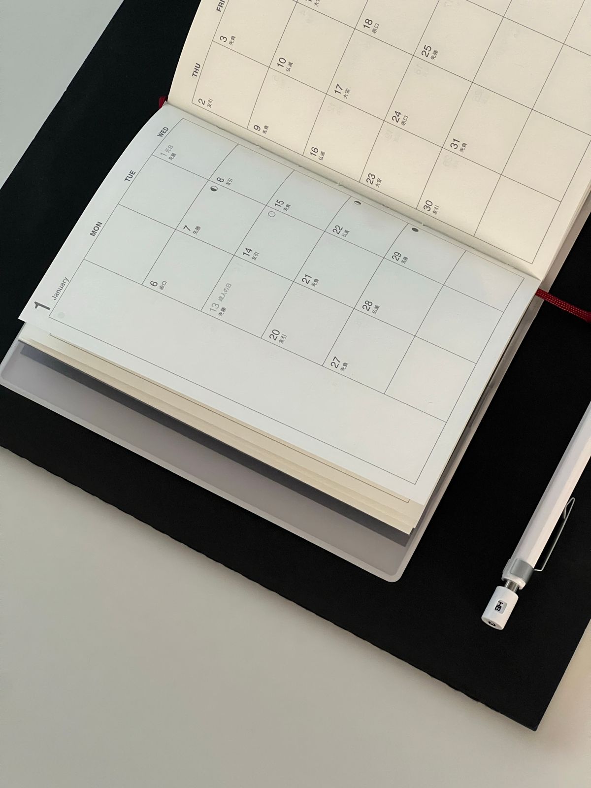 Open calendar with a pen and notebook on a desk