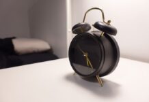Couples Therapy When You Work Night Shifts: Scheduling Without Losing Sleep Black vintage-style alarm clock on a bedside table
