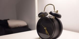Black vintage-style alarm clock on a bedside table