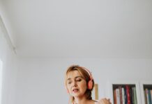 Woman using headphones and a laptop for a video call at home