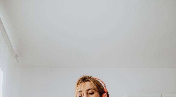 Woman using headphones and a laptop for a video call at home