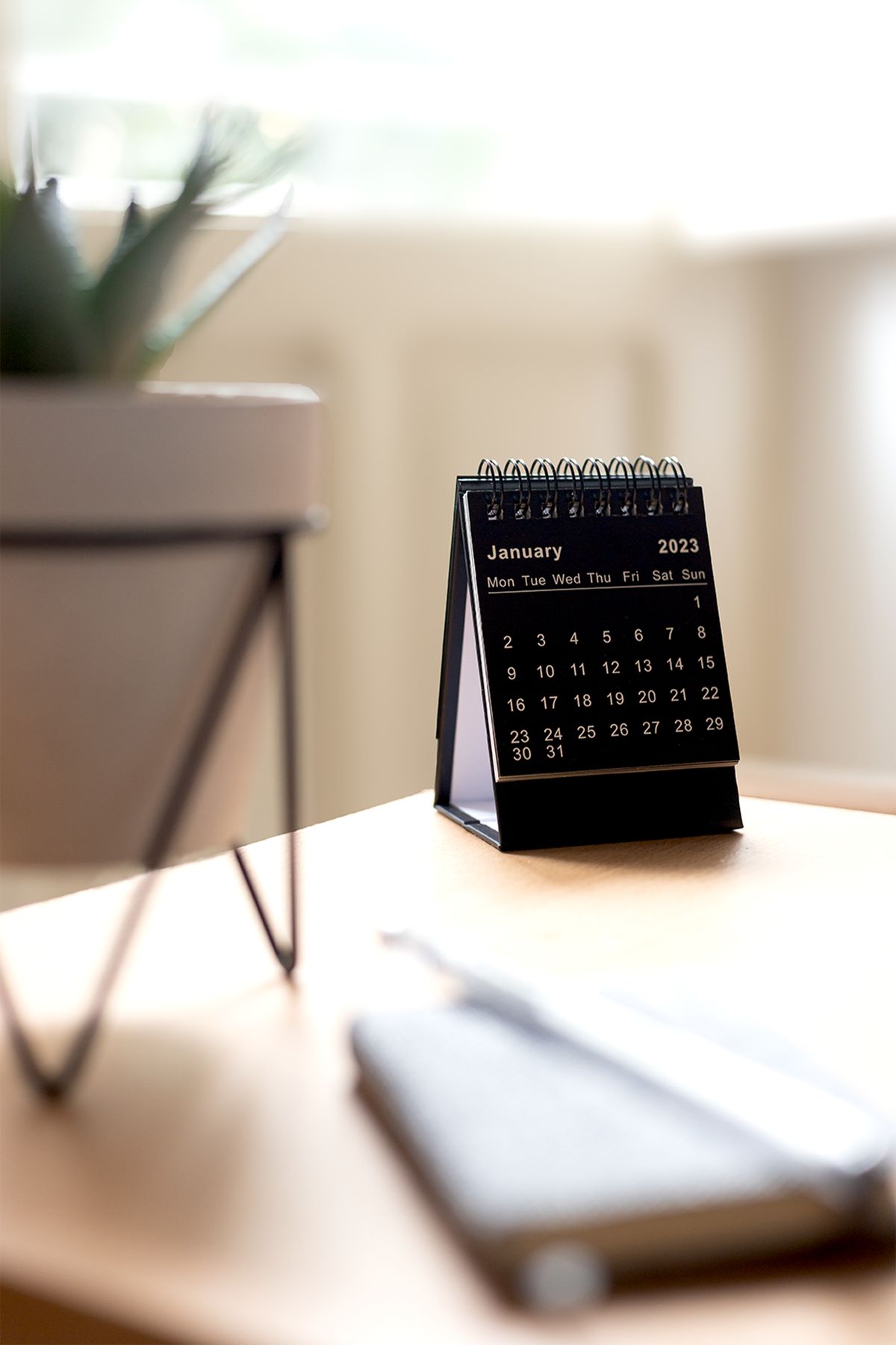 Desk calendar standing beside a notebook