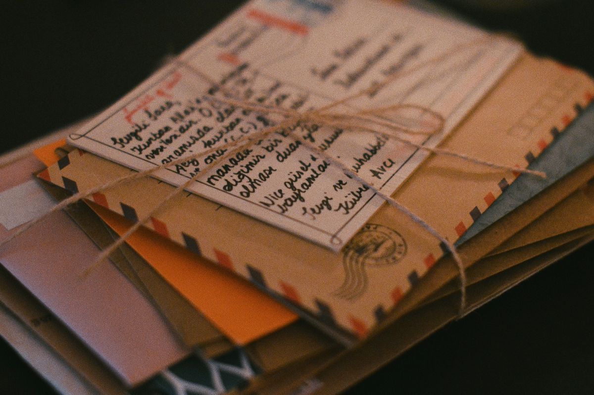 Bundle of old letters tied with twine on a dark tabletop
