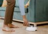 Person pouring dry dog food into a stainless steel bowl at home