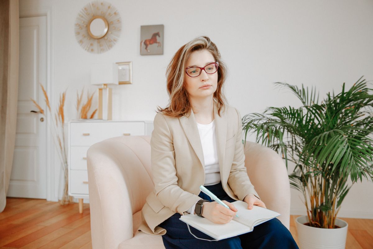 Therapist holding a notebook and taking notes during a session
