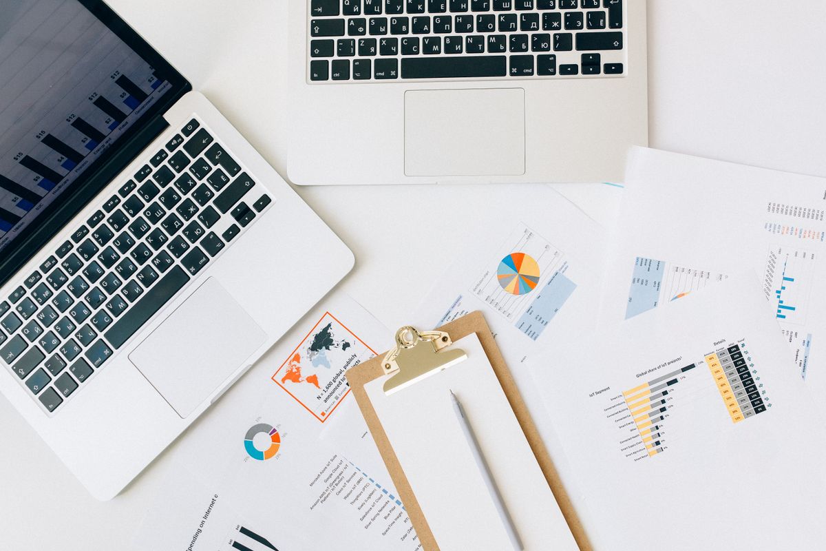 Laptops and printed charts arranged on a work desk